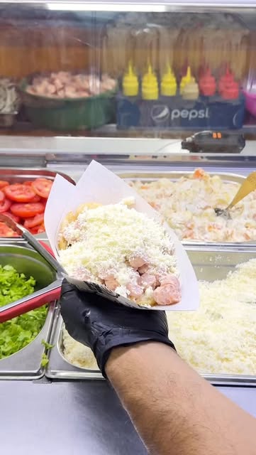 Arepa rellena y cubierta con queso